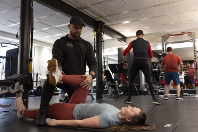 Personal trainer in Islington providing assisted stretching to improve mobility and flexibility during one-on-one training